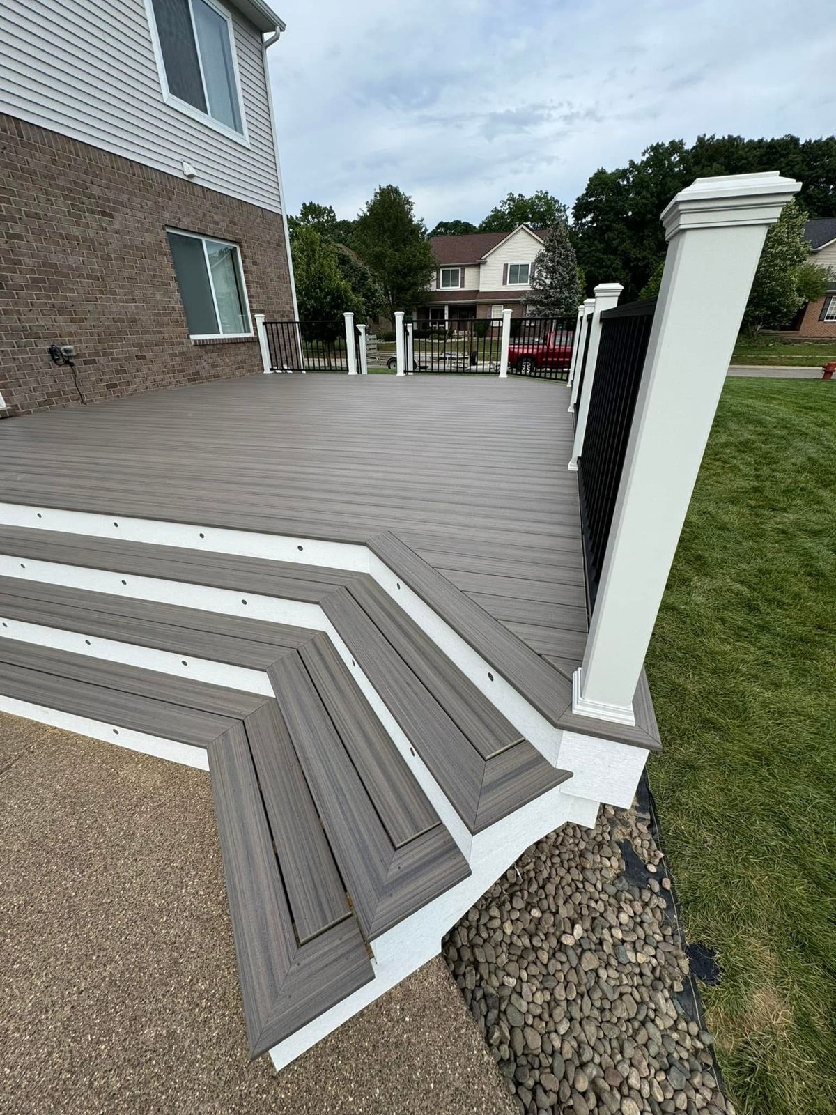 Composite deck with curved steps and white trim